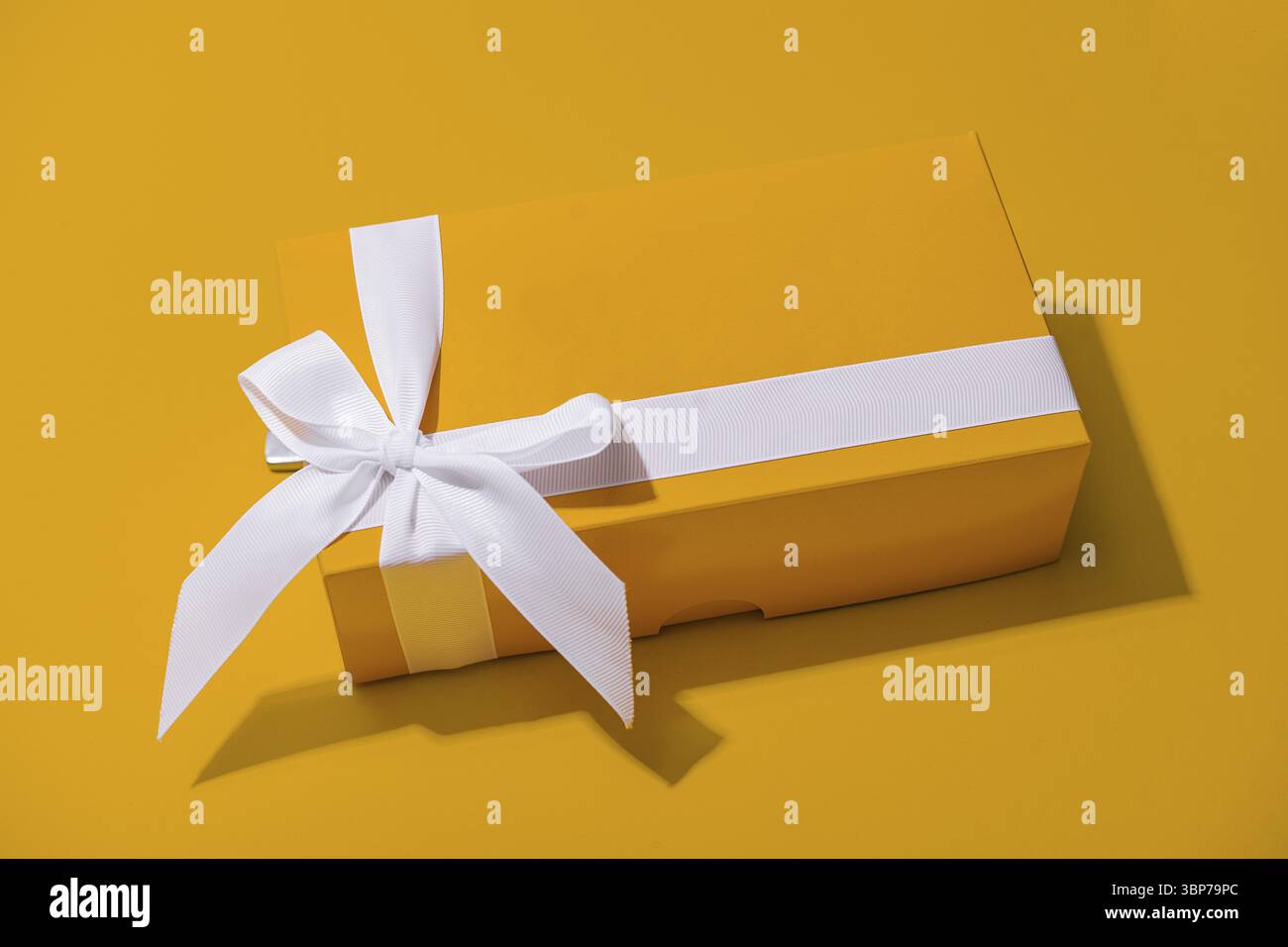 Cibo, confezione regalo gialla con nastro bianco isolato su giallo Foto Stock