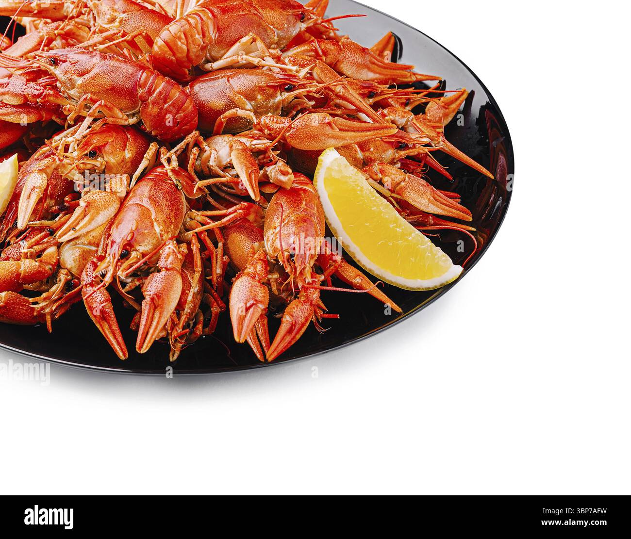 Cibo, Una generosa porzione di gambero rosso brillante è presentata su un piatto nero, guarnita con una fetta di limone. Perfetto per gli amanti del pesce a un festival Foto Stock