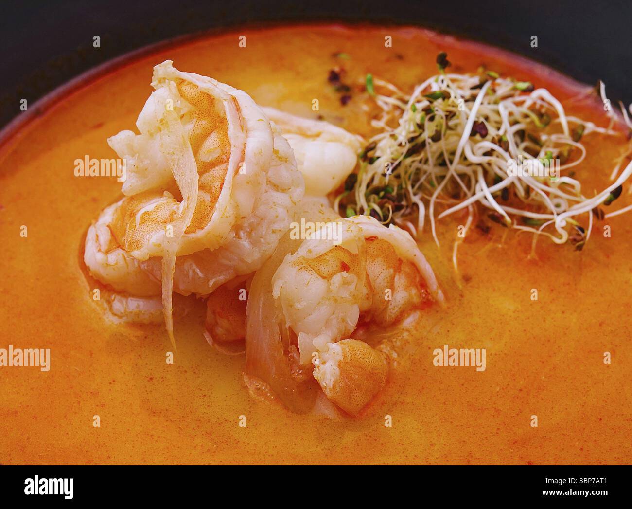 Cibo, tradizionale zuppa tailandese Tom Yam in ciotola nera Foto Stock