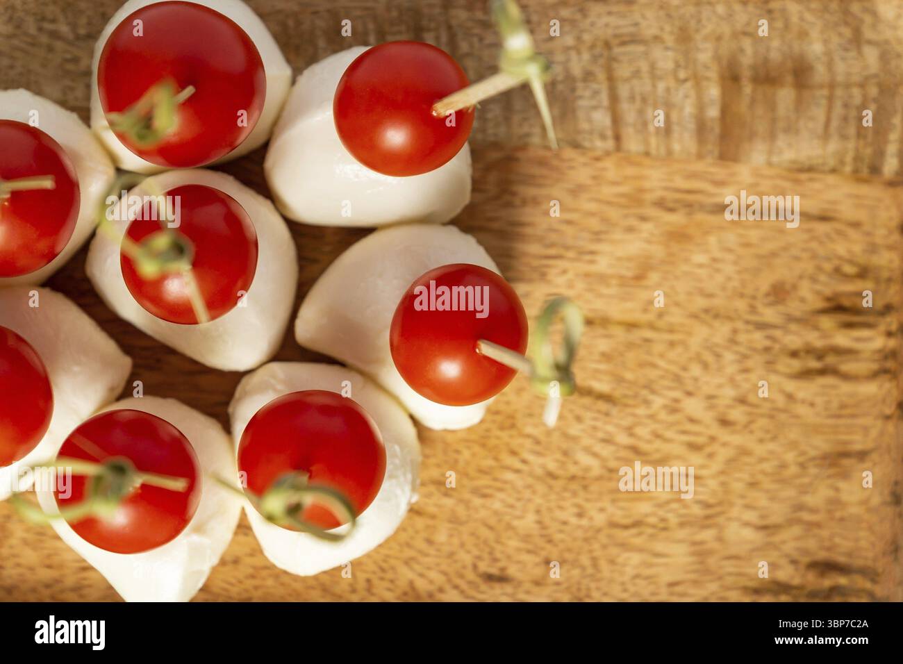 Vista dall'alto dei pomodori ciliegini e della mozzarella sui bastoncini. Sfondo cibo con spazio di copia Foto Stock