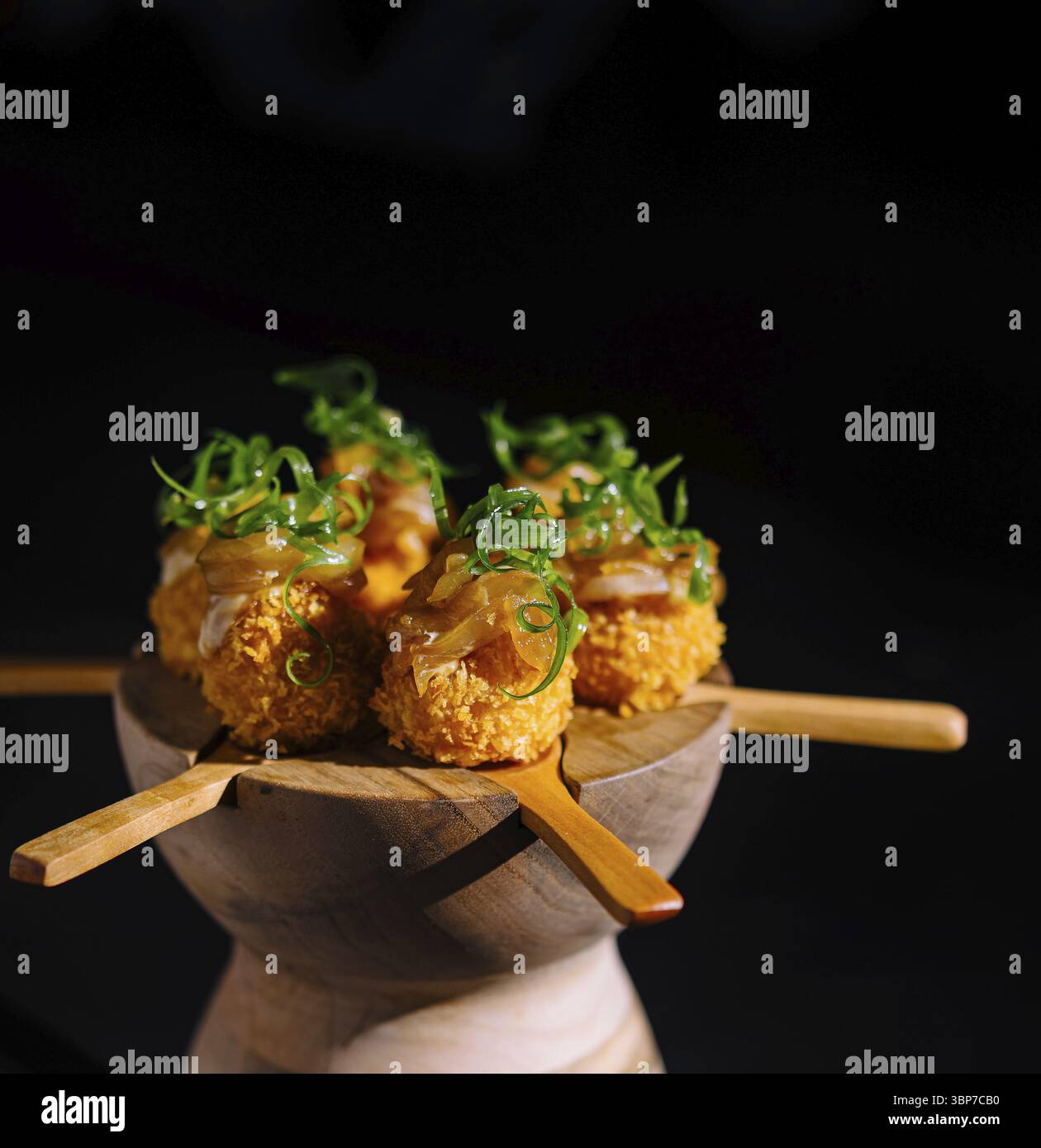 Cibo, presentazione artistica di sushi pop unici guarniti con cipolla verde su un elegante server di legno Foto Stock