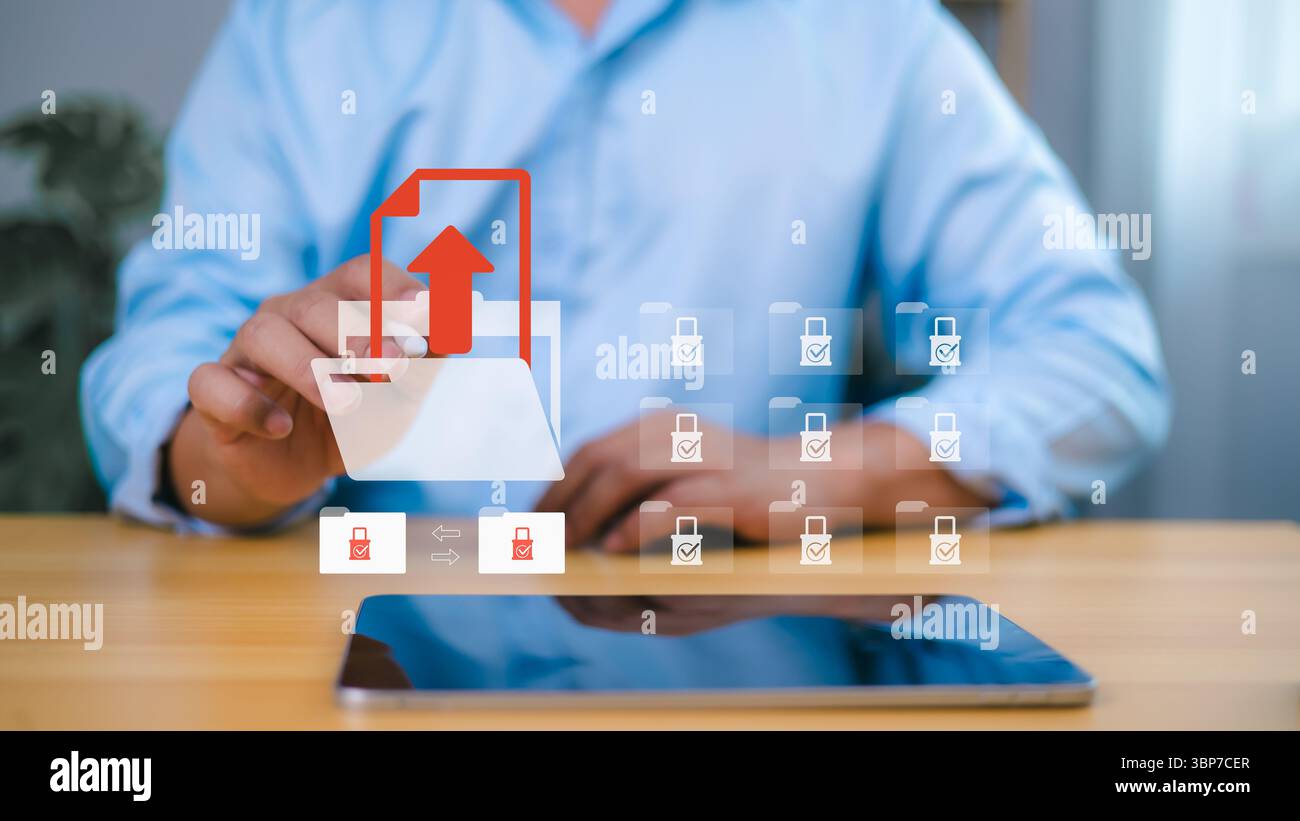 Uomo d'affari che carica file sicuri utilizzando l'icona della cartella digitale sullo schermo virtuale, protezione dei dati e concetto di tecnologia di storage cloud. Foto Stock
