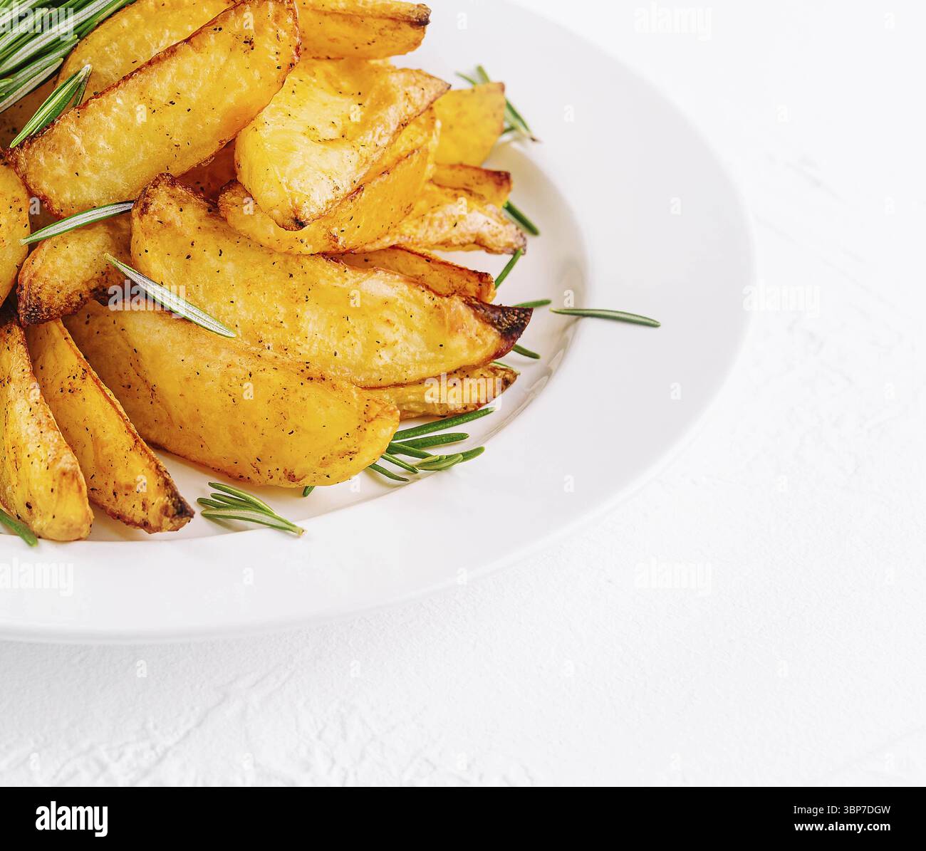 Cibo, patate al forno con rosmarino sul piatto Foto Stock