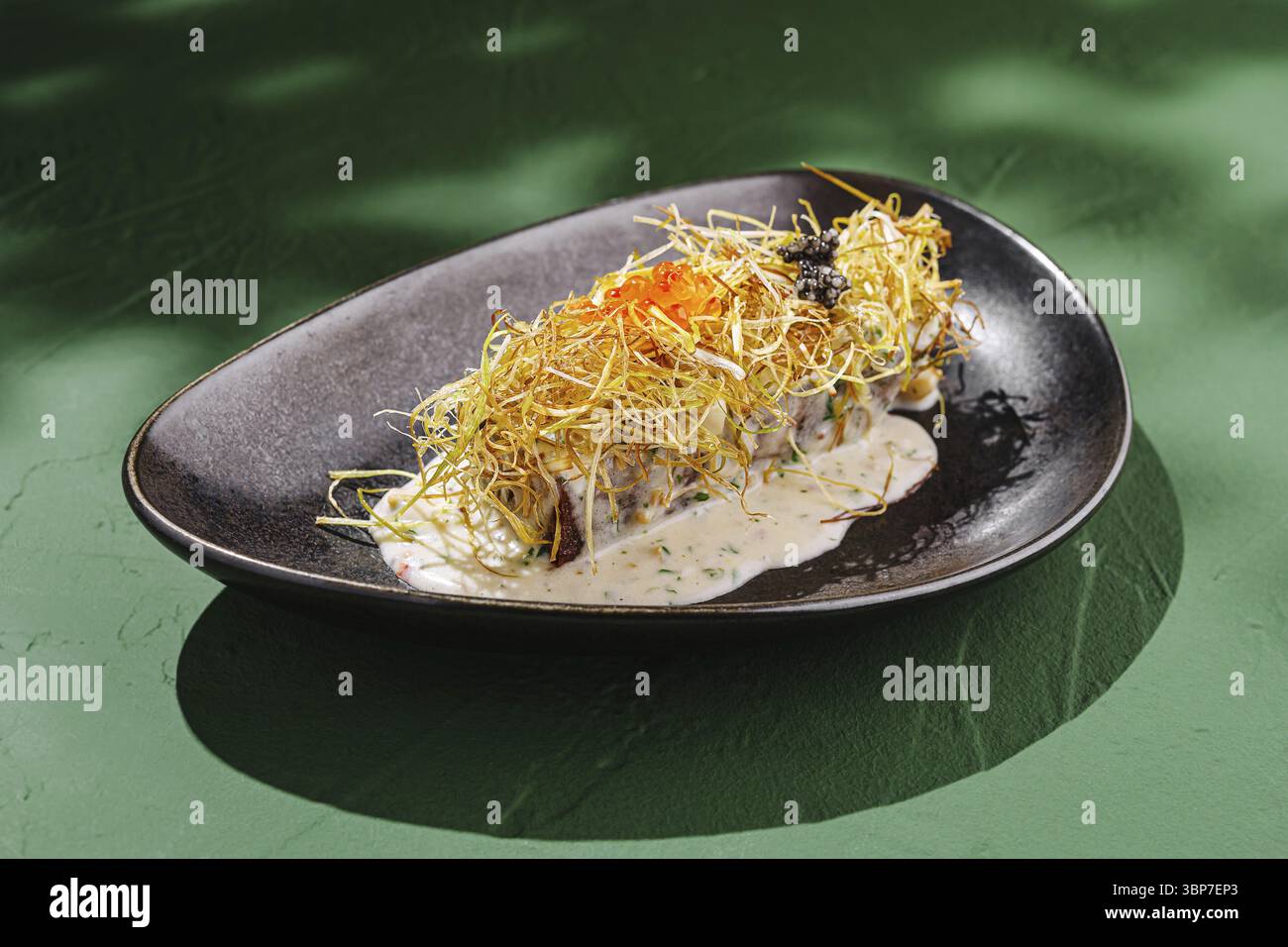 Cibo, Un piatto gourmet propone pesce fresco, condito con elementi croccanti e servito con una salsa cremosa. I colori e le texture vivaci creano un'atmosfera Foto Stock