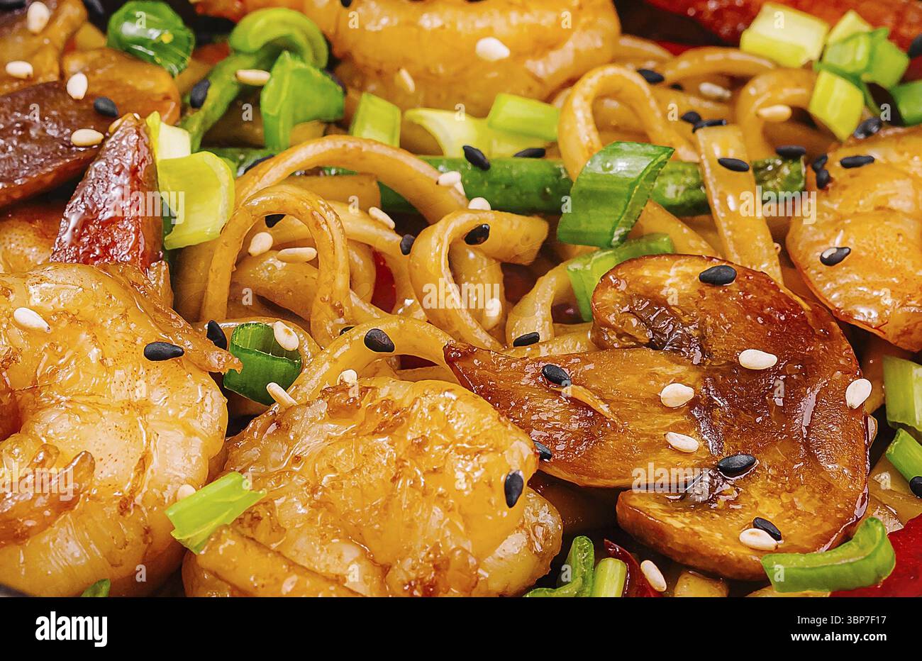 Cibo, spaghetti saltati con gamberi, verdure e semi di sesamo Foto Stock