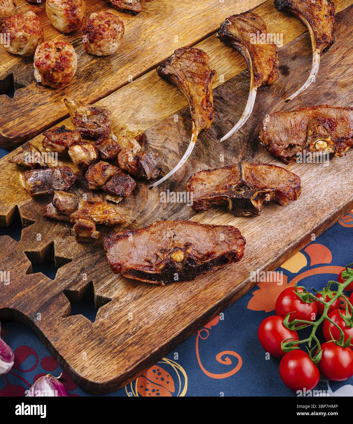 Cibo, assortimento di deliziose costolette di agnello alla griglia, polpette e tagli di vitello sono disposti su tavole di legno rustiche, pronte per essere gustate Foto Stock