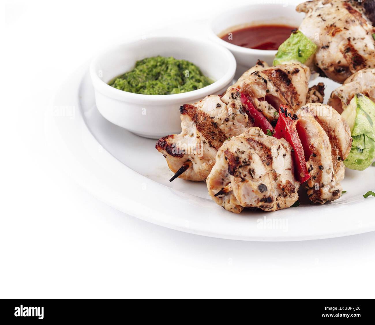 Cibo, spiedini di pollo alla griglia con zucchine, peperoni e salse da immersione sono placcati e pronti per essere gustati Foto Stock