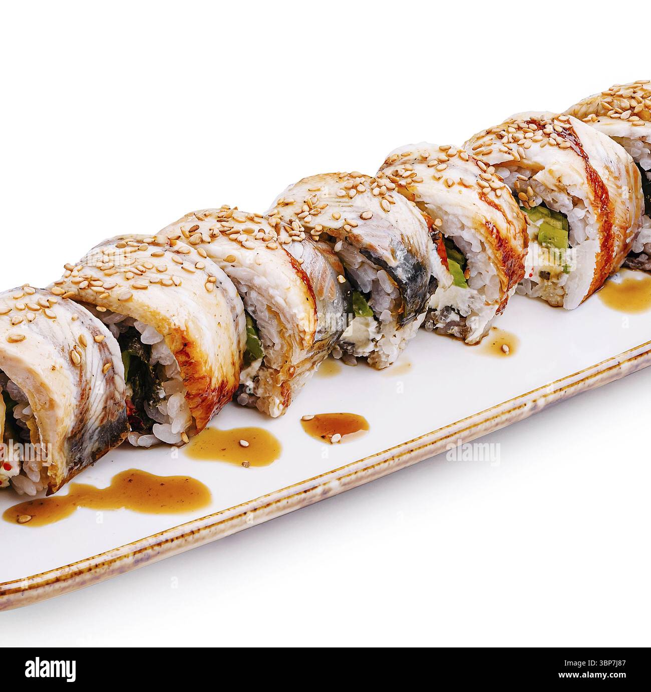 Cibo, Un sushi roll ben organizzato con strati di pesce e verdure, ricoperti di semi di sesamo, che poggiano su un piatto bianco con un filo di S. Foto Stock