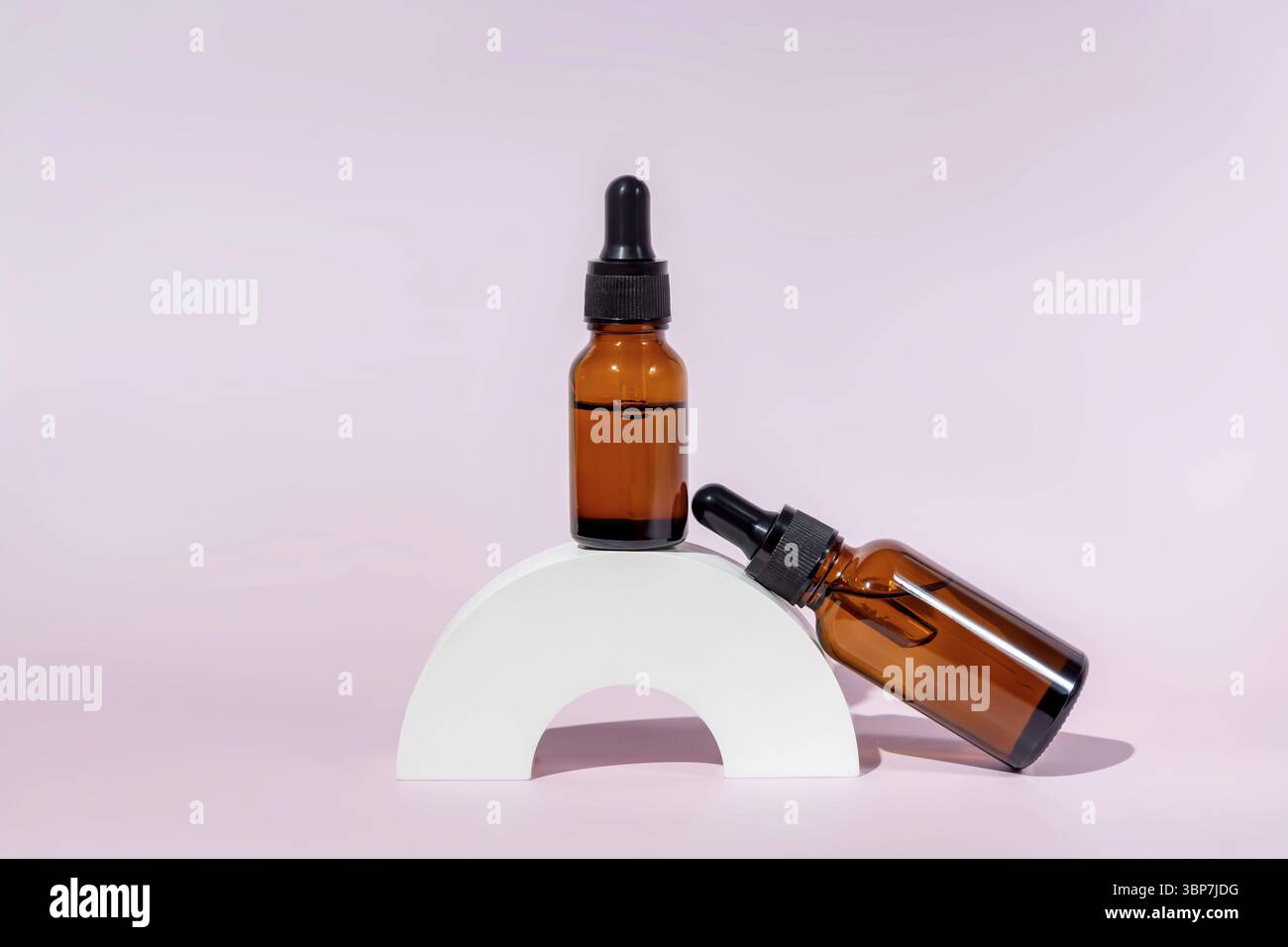 Bottiglie cosmetiche in vetro scuro con olio o siero per la cura della pelle su podio di cemento speciale su sfondo di inchiostro. Concetto di cura naturale della pelle. Ombre dure Foto Stock