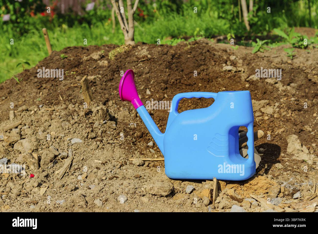 Lattone di irrigazione in plastica blu a terra. Attrezzature da giardino Foto Stock