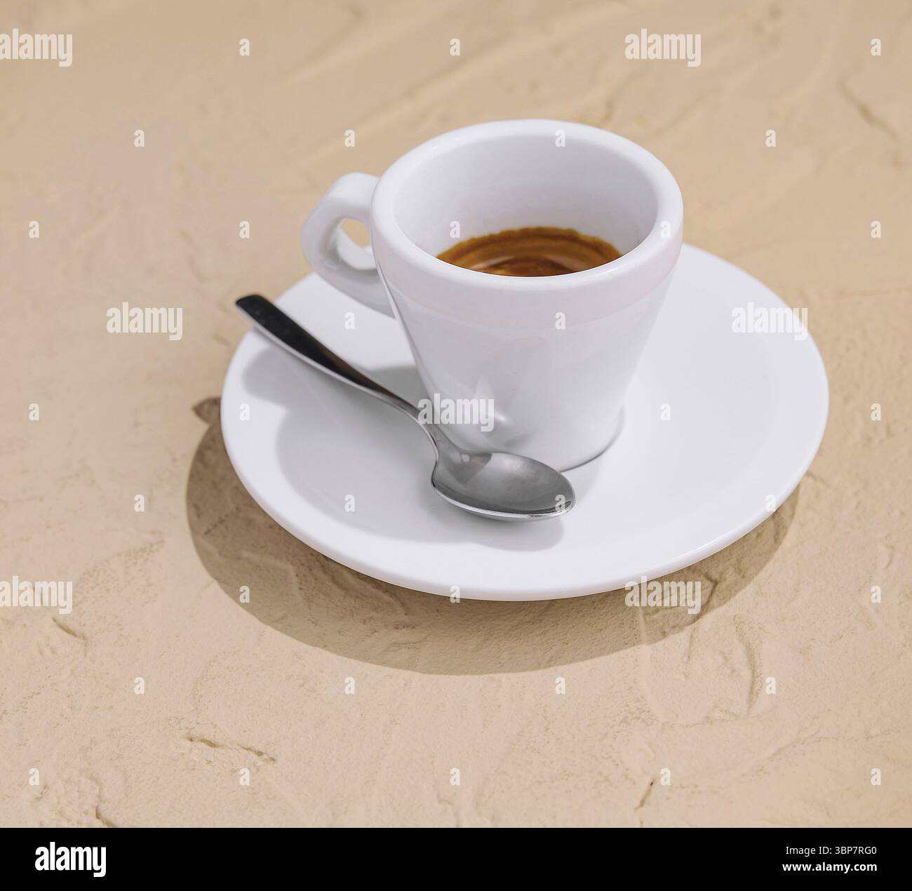 Cibo, serena pausa caffè mattutina con un elegante espresso in una tazza bianca su una spiaggia di sabbia, circondato dalla semplicità e dalla bellezza minimalista di un Foto Stock