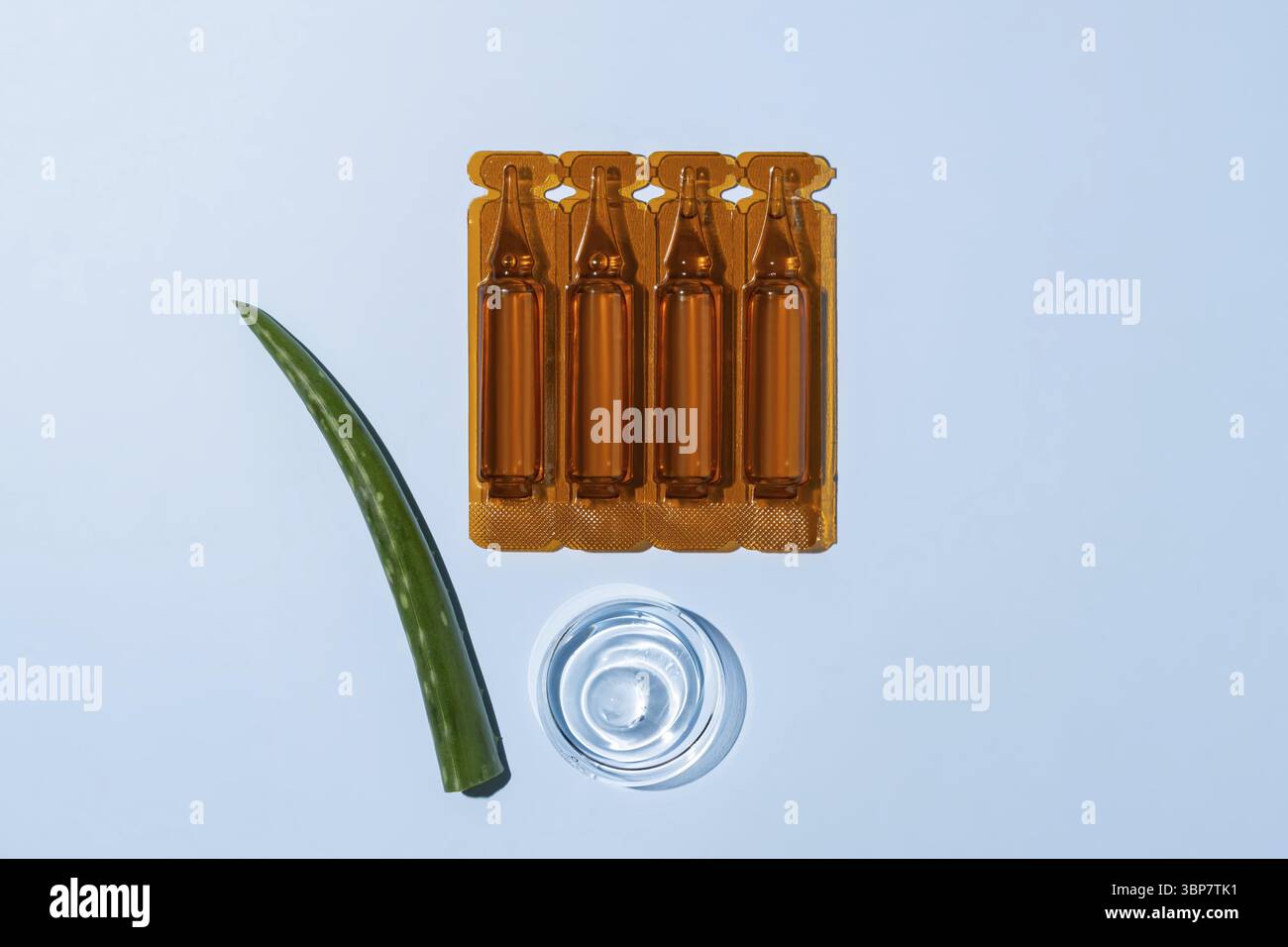 Fiale con estratto di aloe vera per la cura della pelle o il trattamento dei capelli. Prodotto lenitivo per la pelle morbida. campione di gel di aloe in piastra petri su sfondo blu Foto Stock