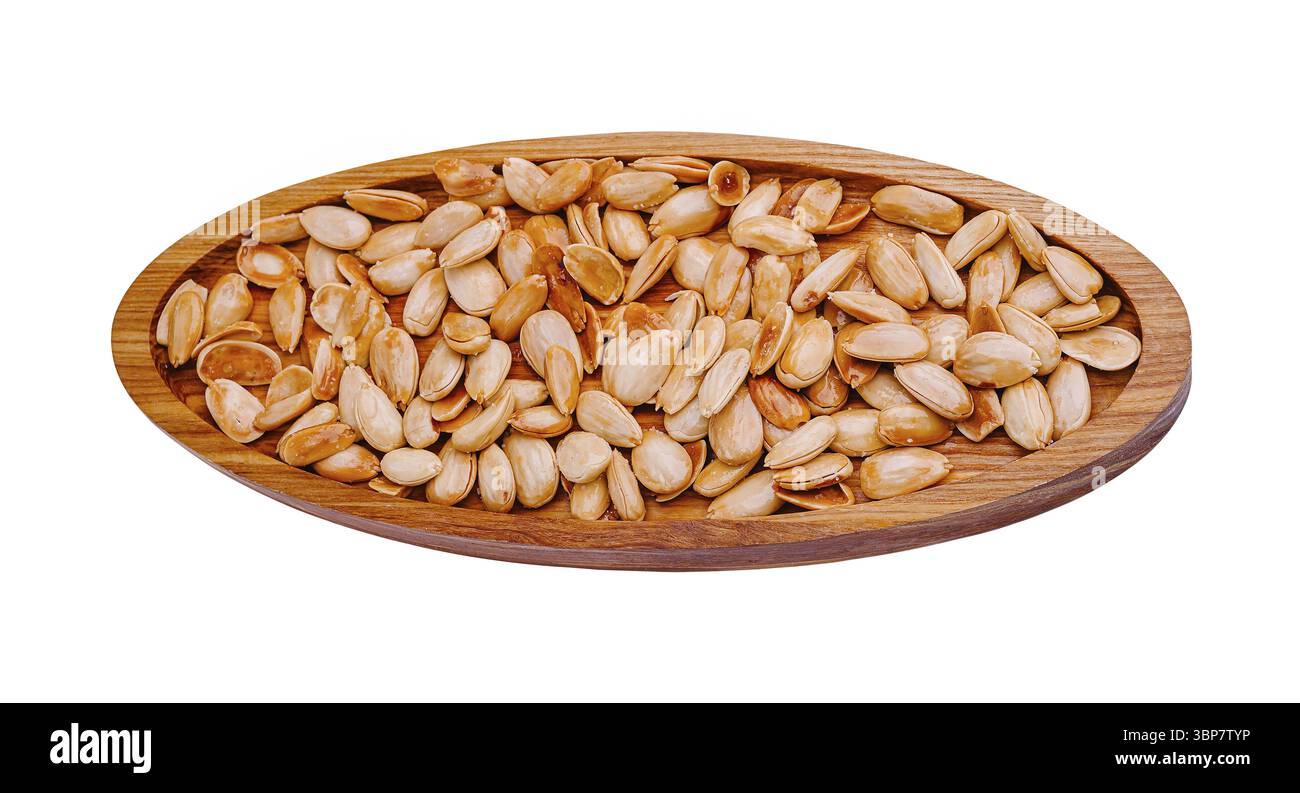 Cibo, semi di zucca arrostiti sono disposti ordinatamente su un piatto rustico di legno. I semi dorati sfoggiano una consistenza croccante, perfetta per gli spuntini o. Foto Stock Cibo, semi di zucca arrostiti sono disposti ordinatamente su un piatto rustico di legno. I semi dorati sfoggiano una consistenza croccante, perfetta per gli spuntini o. Foto Stock