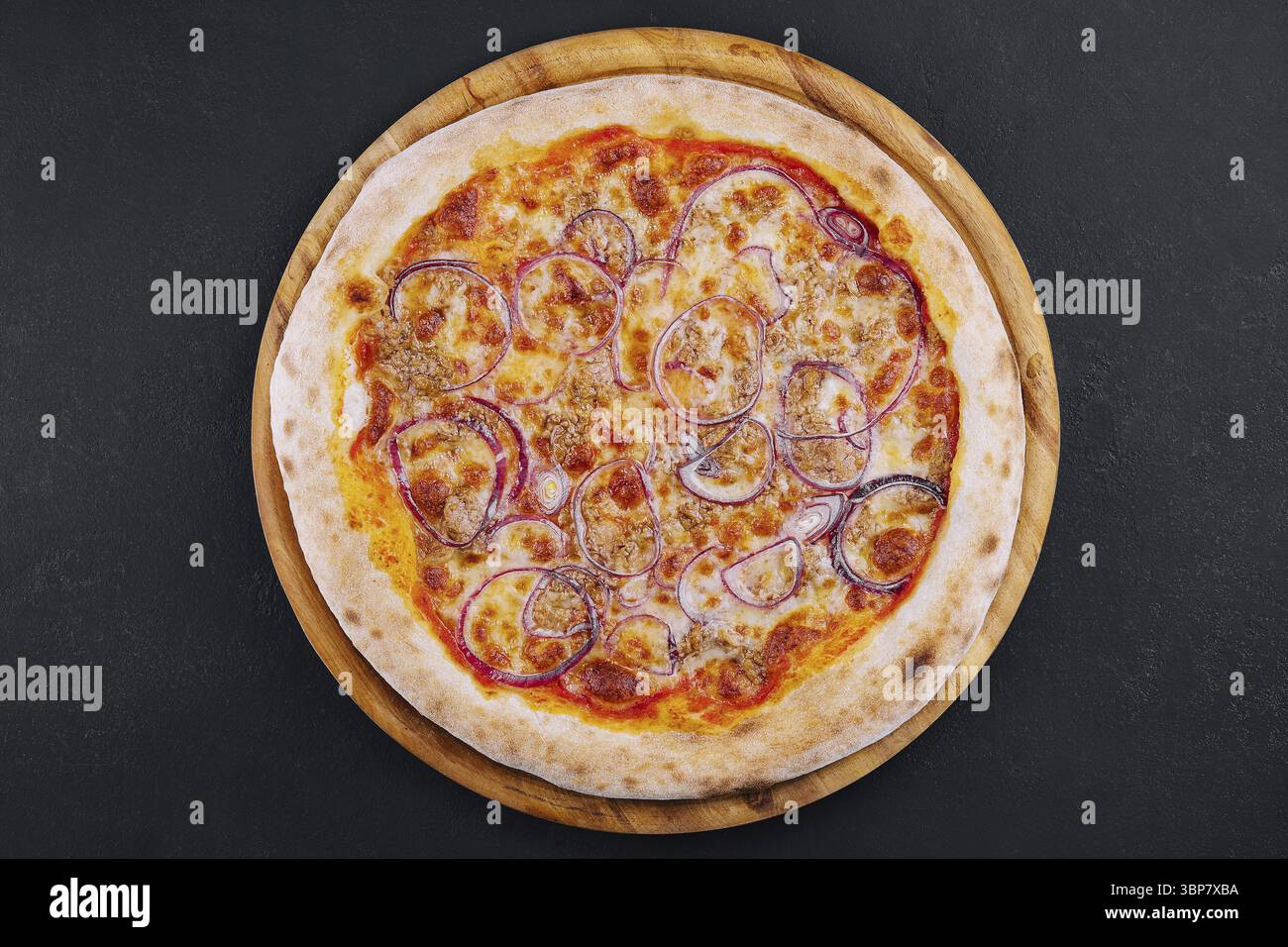 Cibo, Pizza con tonno e cipolla rossa su tagliere di legno Foto Stock