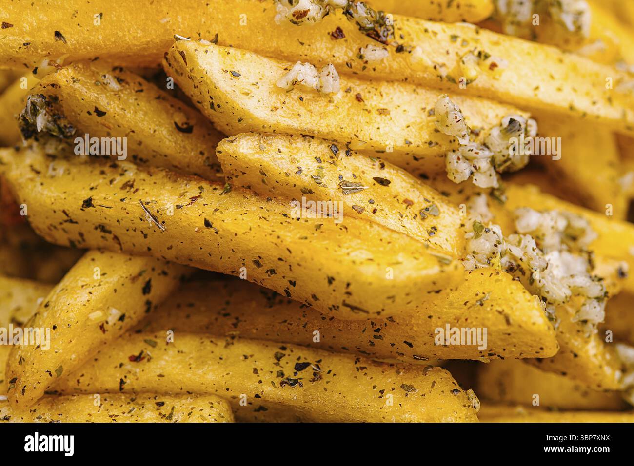 Cibo, Una vista ravvicinata rivela patatine fritte dorate perfettamente cotte. Le patatine sono condite generosamente con erbe aromatiche e cosparse di sale grosso, maki Foto Stock