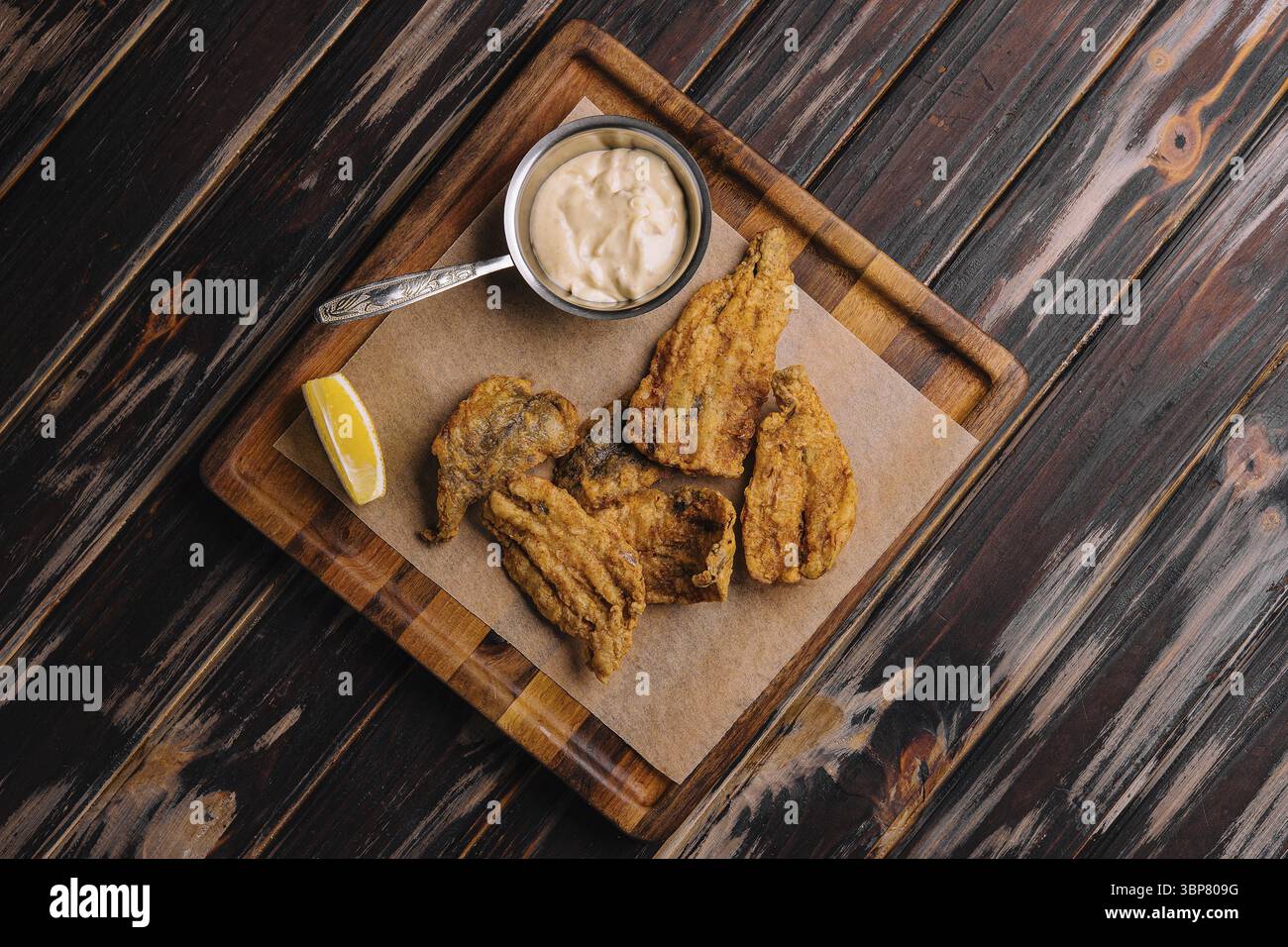 Cibo, pezzi di filetto di merluzzo fritto su vassoio di legno Foto Stock