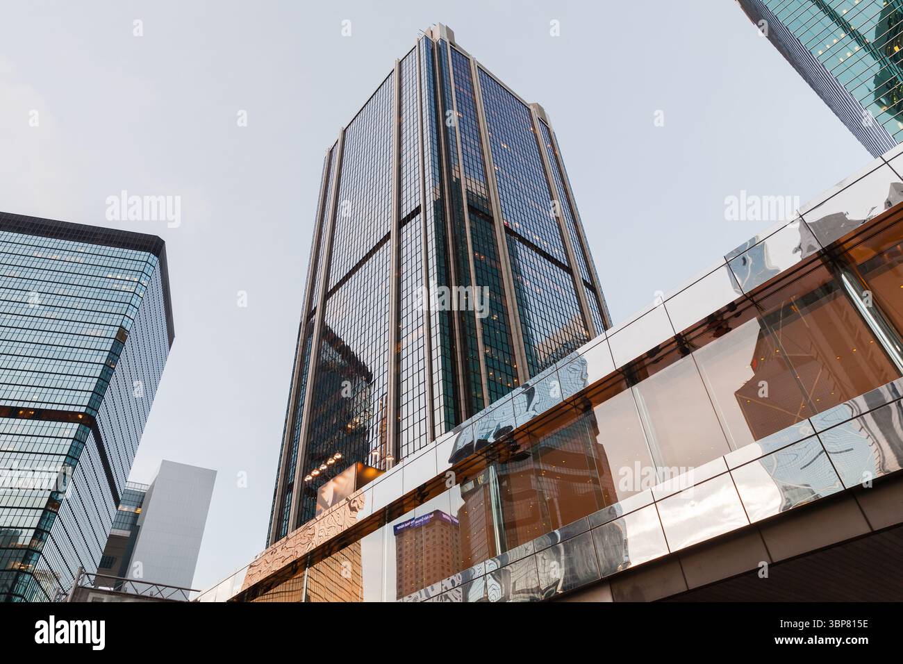 Hong Kong - 11 luglio 2017: Vista dal basso di un alto e moderno grattacielo con finestre in vetro riflettente che simboleggiano la crescita urbana e l'innov architettonico Foto Stock
