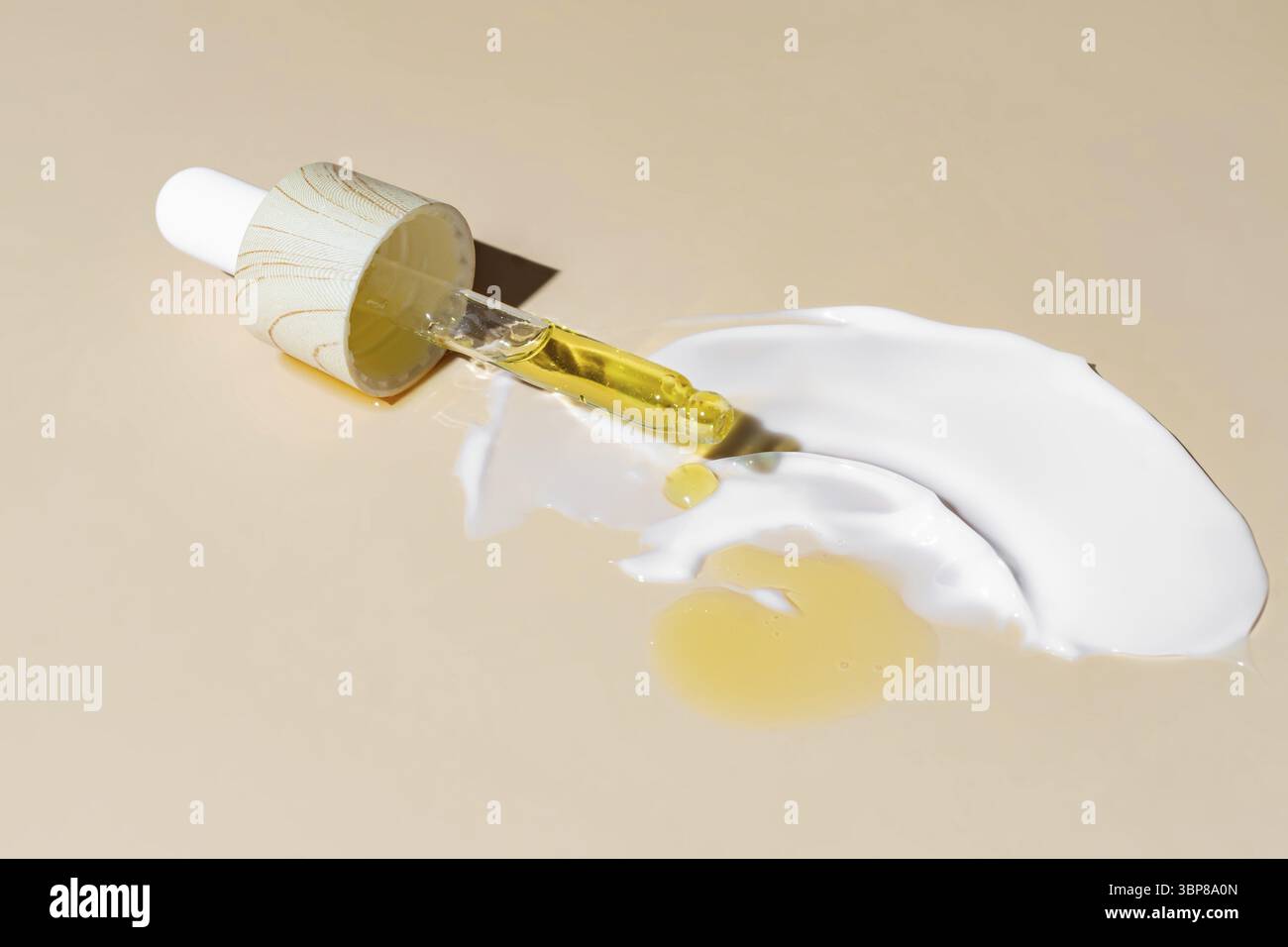 Primo piano della pipetta con il versamento di siero liquido e ombre sullo sfondo beige. Colpo di crema per il viso. Cosmetici alla moda con ombre dure Foto Stock