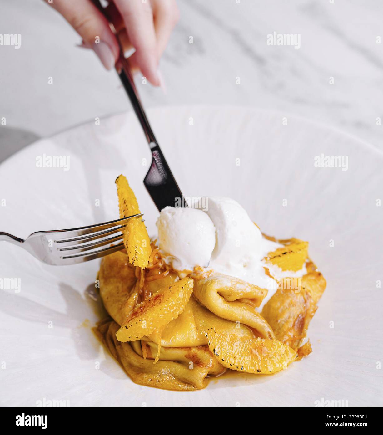 Cibo, deliziosi pancake, cucchiaio di gelato con scorza d'arancia, forchetta in azione Foto Stock
