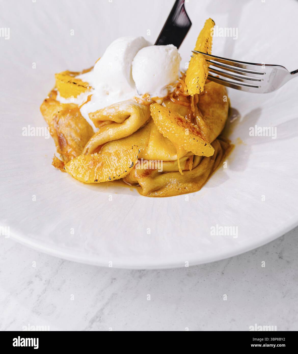 Cibo, deliziosi pancake, cucchiaio di gelato con scorza d'arancia, forchetta in azione Foto Stock