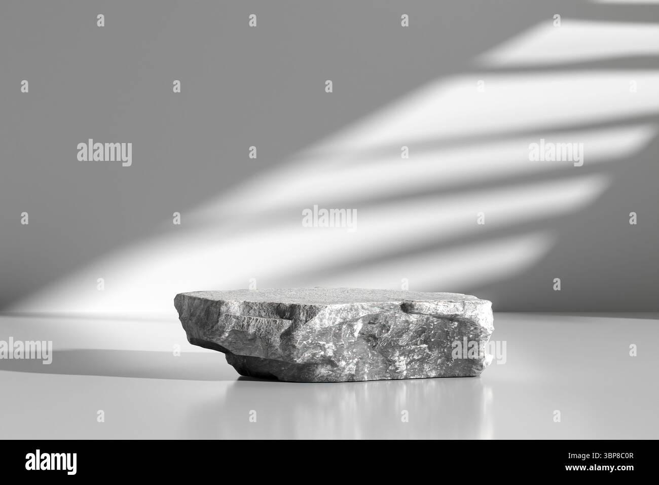 Piedistallo vuoto per il posizionamento del prodotto illuminato dalla luce del sole che passa attraverso le tende, creando ombre su sfondo bianco Foto Stock