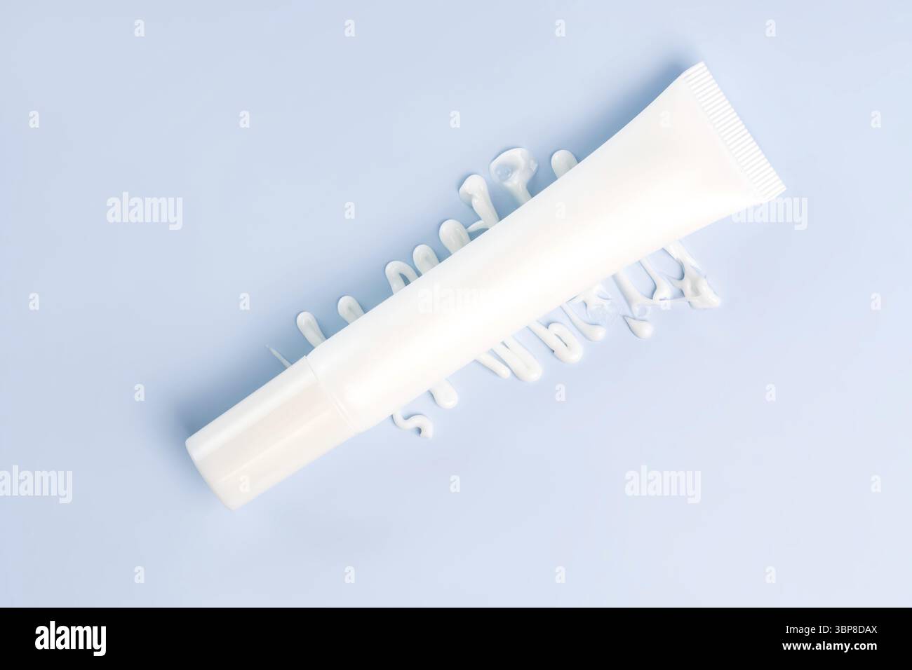 Tubetto di crema su sfondo blu. Confezione di plastica vuota per prodotti cosmetici per la cura della pelle. Lozione bianca senza marchio, balsamo, crema per le mani, mockup dentifricio con panna Foto Stock
