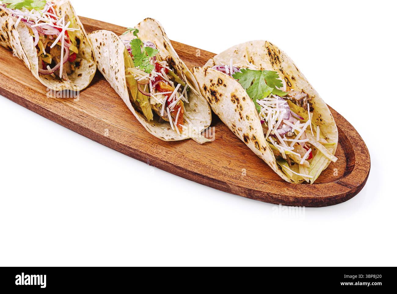 Cibo, tacos ripieni di carne condita, verdure fresche ed erbe aromatiche sono disposti in modo ordinato su un tavolo da servizio in legno. Il pasto offre un ambiente colorato e piacevole Foto Stock