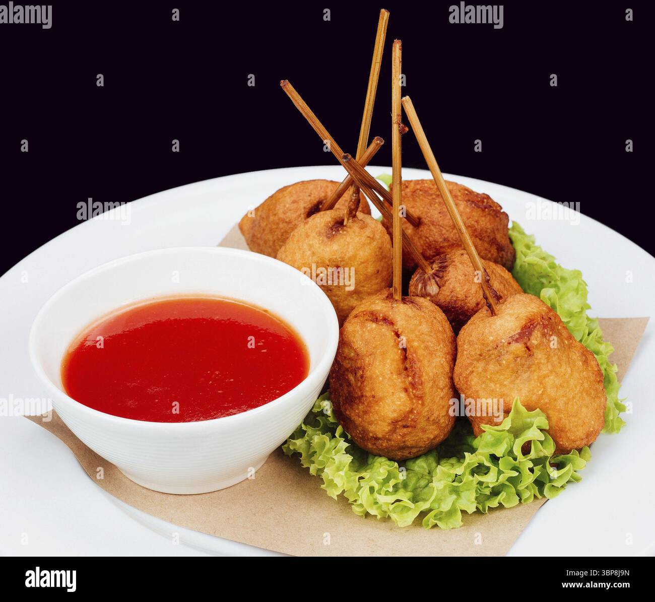 Cibo: Pepite di pollo croccanti servite con una ciotola di salsa piccante su un piatto bianco Foto Stock