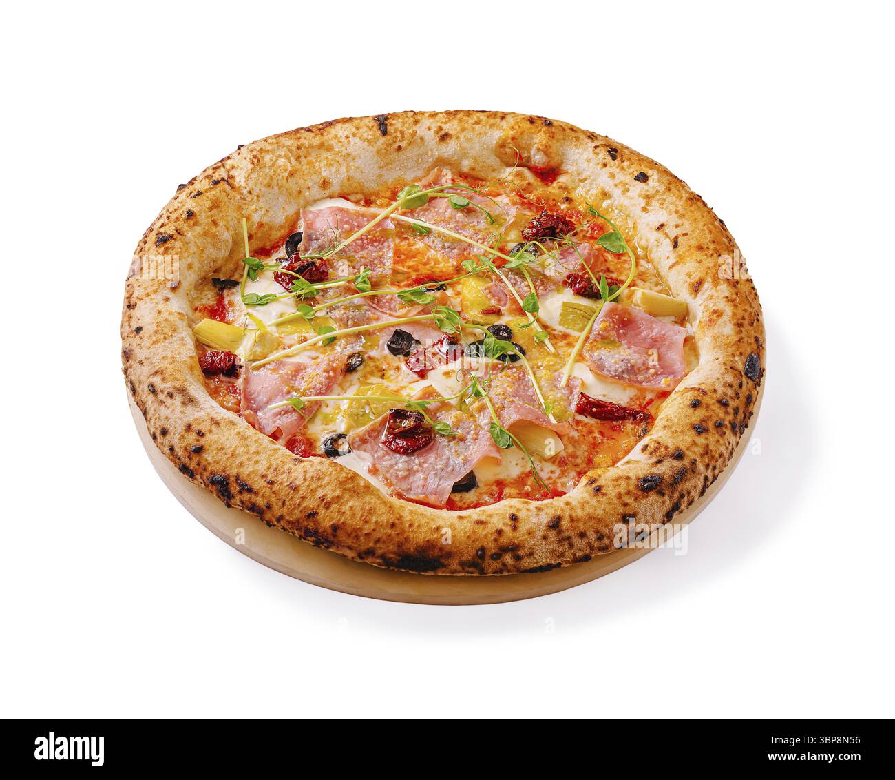 Il cibo, Una pizza cotta al forno a legna condita con prosciutto, olive ed erbe aromatiche è presentato su un piatto di legno. La crosta dorata è perfettamente bruciata, sho Foto Stock