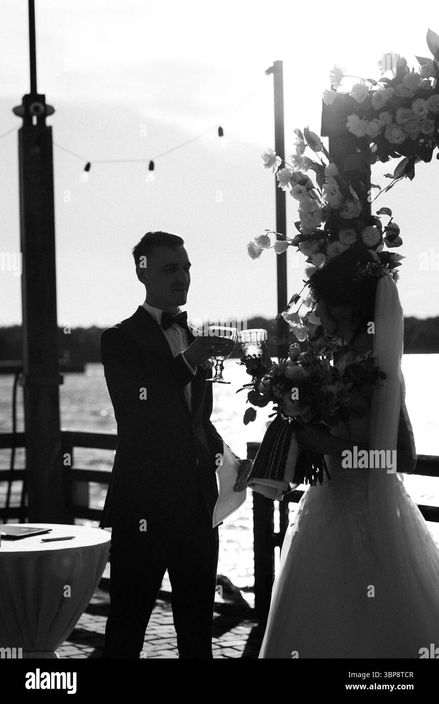 cerimonia di nozze su un alto molo vicino al fiume con gli ospiti invitati Foto Stock