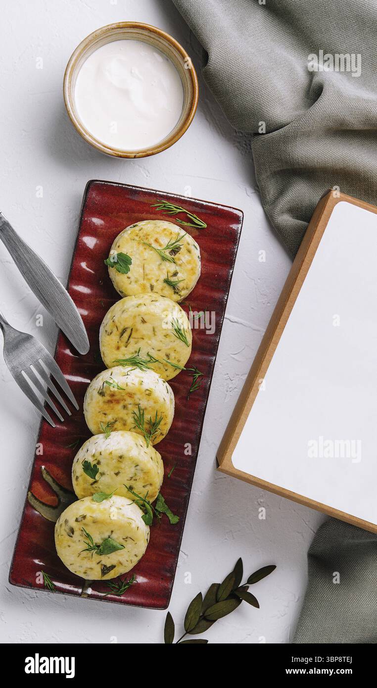 Cibo, frittelle di formaggio cottage servite su un piatto marrone accanto a una scatola vuota, pronte per il testo Foto Stock