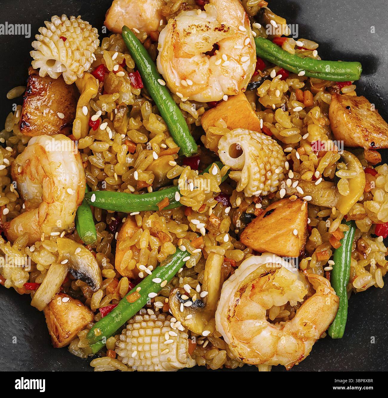 Cibo, vista dall'alto di un saporito gamberetto fritto con verdure miste e riso servito su un piatto scuro Foto Stock