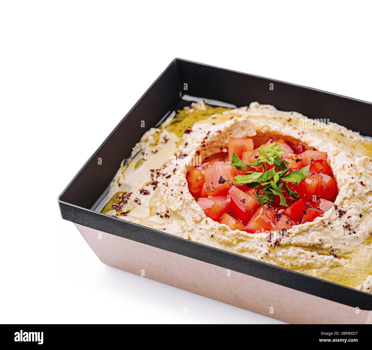 Cibo, Una porzione di hummus cremoso è presentata in un piatto nero, guarnita con pomodori a dadini ed erbe fresche. Il piatto è condito con olio d'oliva, sho Foto Stock