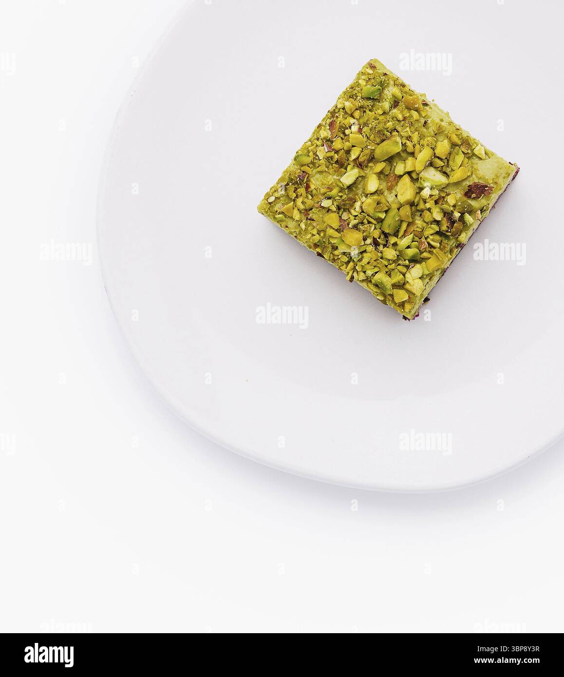 Cibo, vista dall'alto di una deliziosa pasticceria al pistacchio su un piatto bianco pulito, isolato su uno sfondo bianco Foto Stock