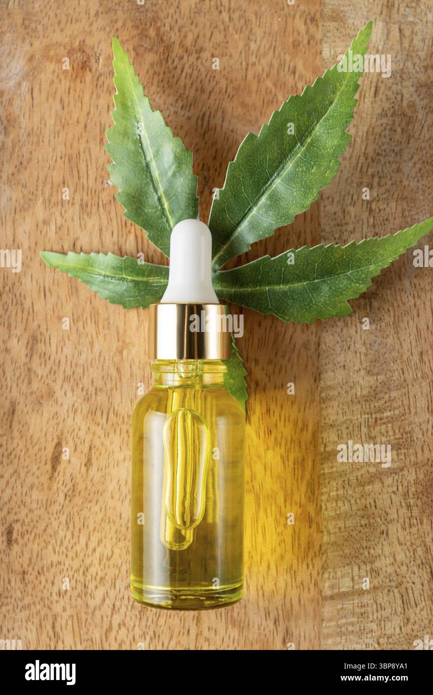 Estratto di erbe e foglia di cannabis in contagocce trasparente. Concetto di eco-cosmetica naturale Foto Stock