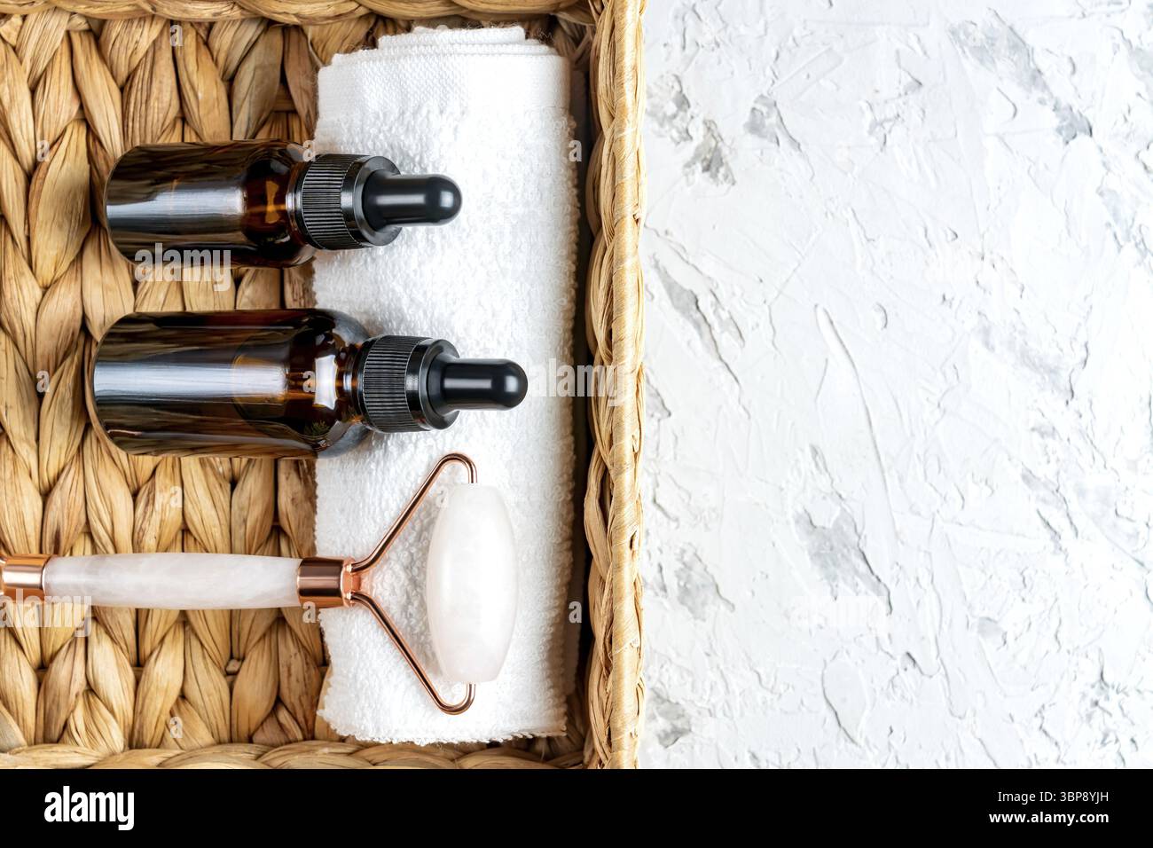 Set regalo per la cura del viso e della pelle del corpo. Lozione, olio essenziale, rullo al quarzo frontale in un cestello. Set da bagno di bellezza per il corpo e il viso Foto Stock