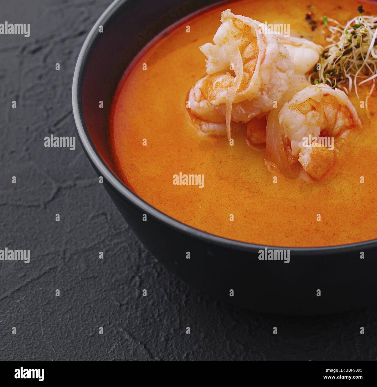 Cibo, tradizionale zuppa tailandese Tom Yam in ciotola nera Foto Stock