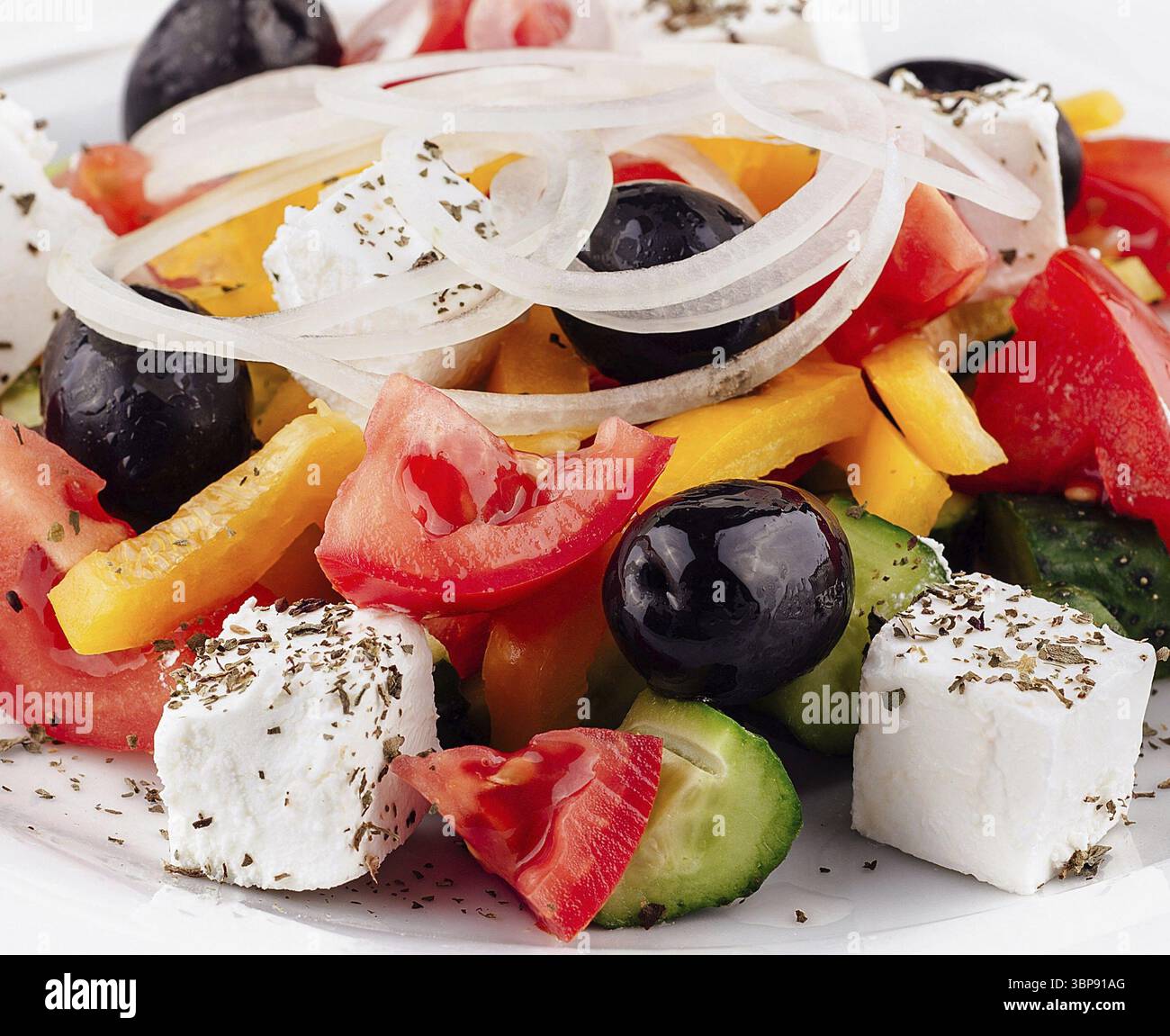 Cibo, insalata greca fresca e colorata con succosi ingredienti cosparsi di erbe aromatiche Foto Stock