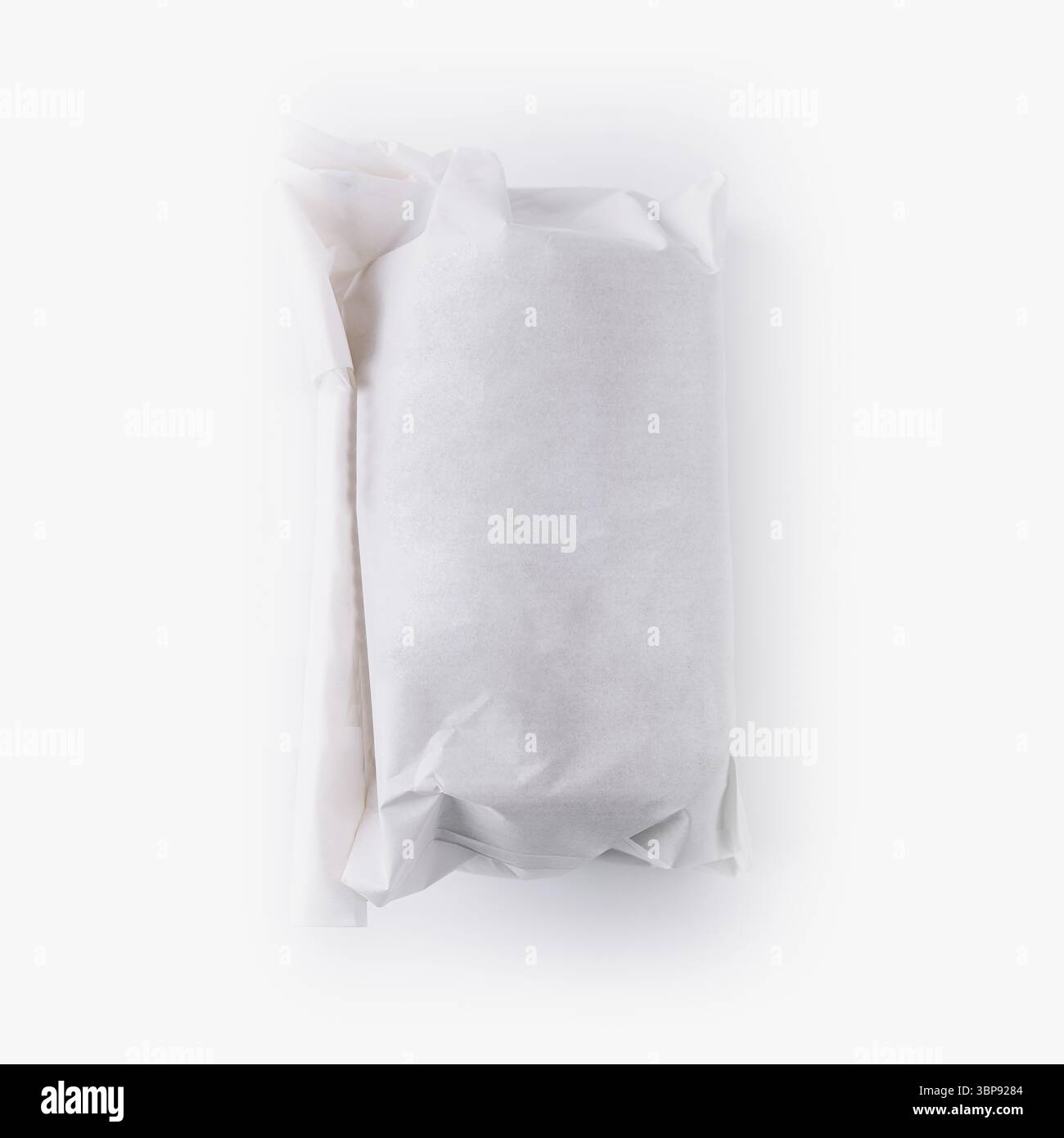 Cibo, Un sandwich ben confezionato si siede pazientemente, racchiuso in carta bianca, promettendo un pasto appagante e gustoso. Gli ingredienti freschi ti aspettano Foto Stock