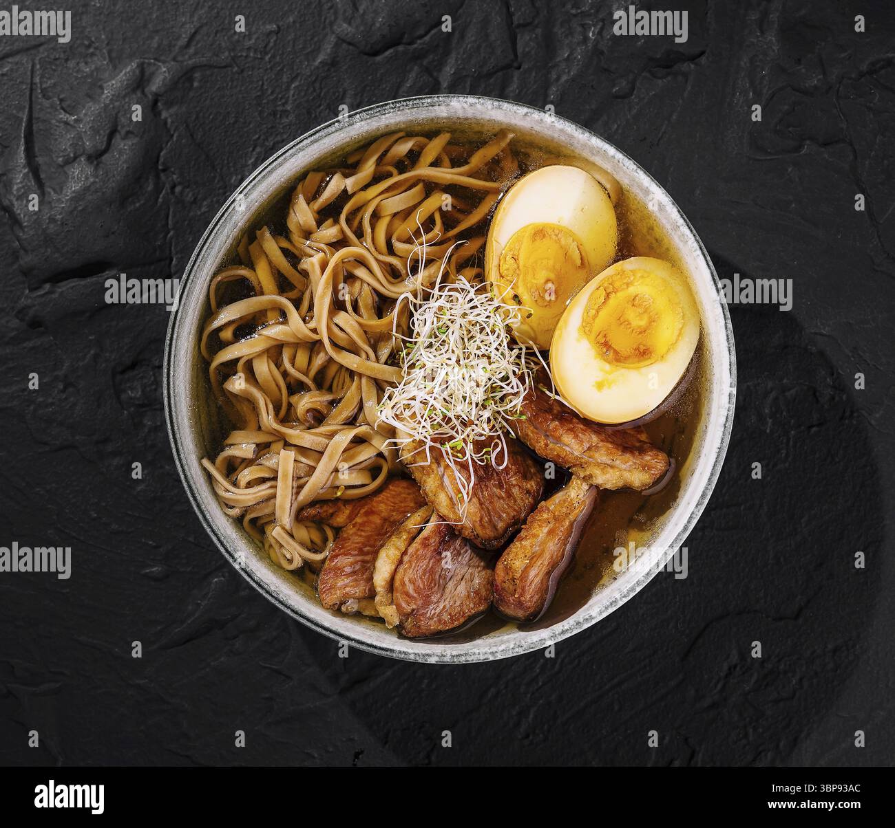 Cibo, vista dall'alto di una deliziosa ciotola di noodle di ramen con succulente fette di maiale, uova e germogli Foto Stock