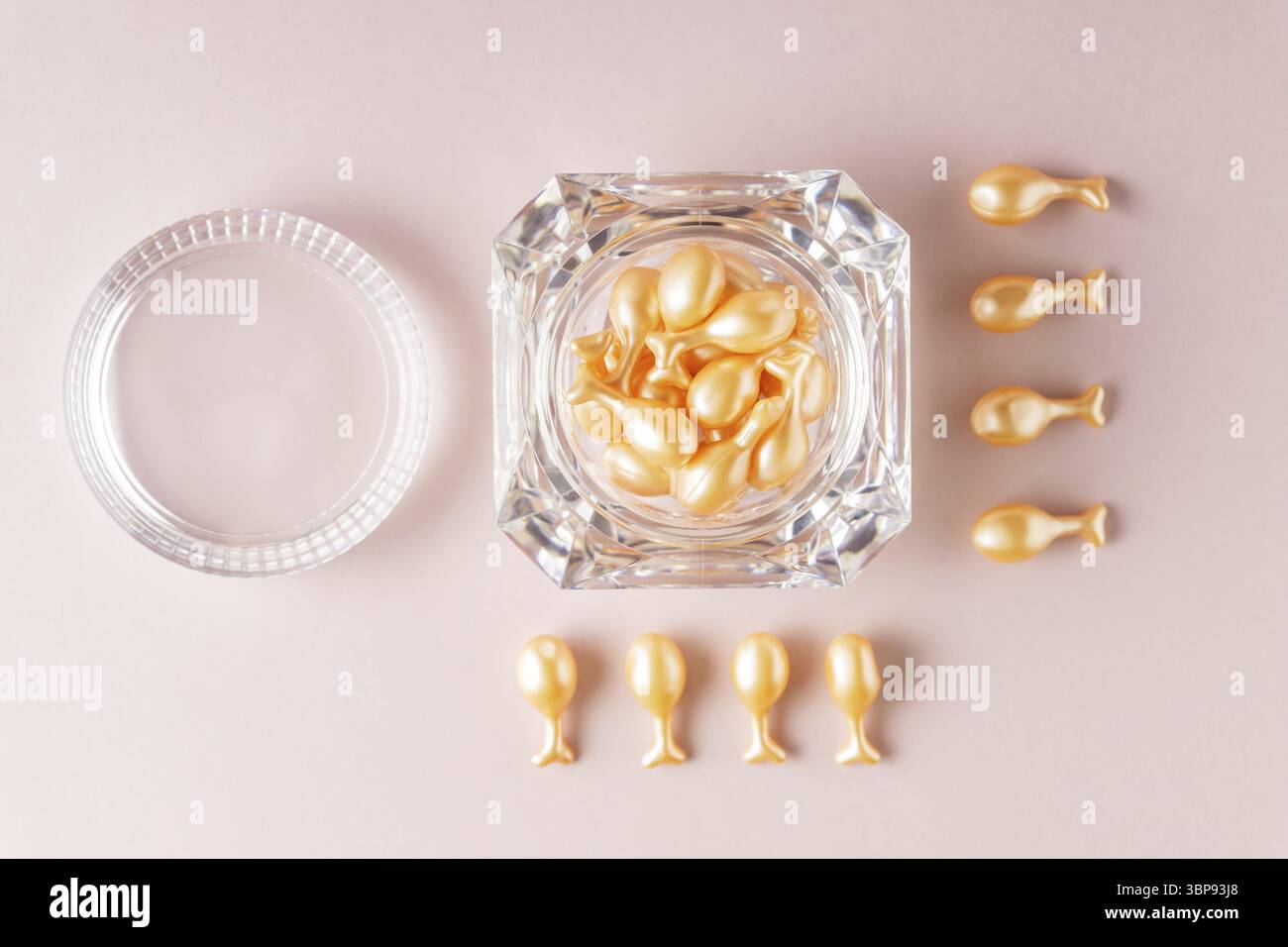 Capsule di olio per la cura del viso su sfondo rosa. olio nutriente monouso per pelle secca e danneggiata. terapia antiage. routine di bellezza quotidiana. concetto di battito in testa Foto Stock