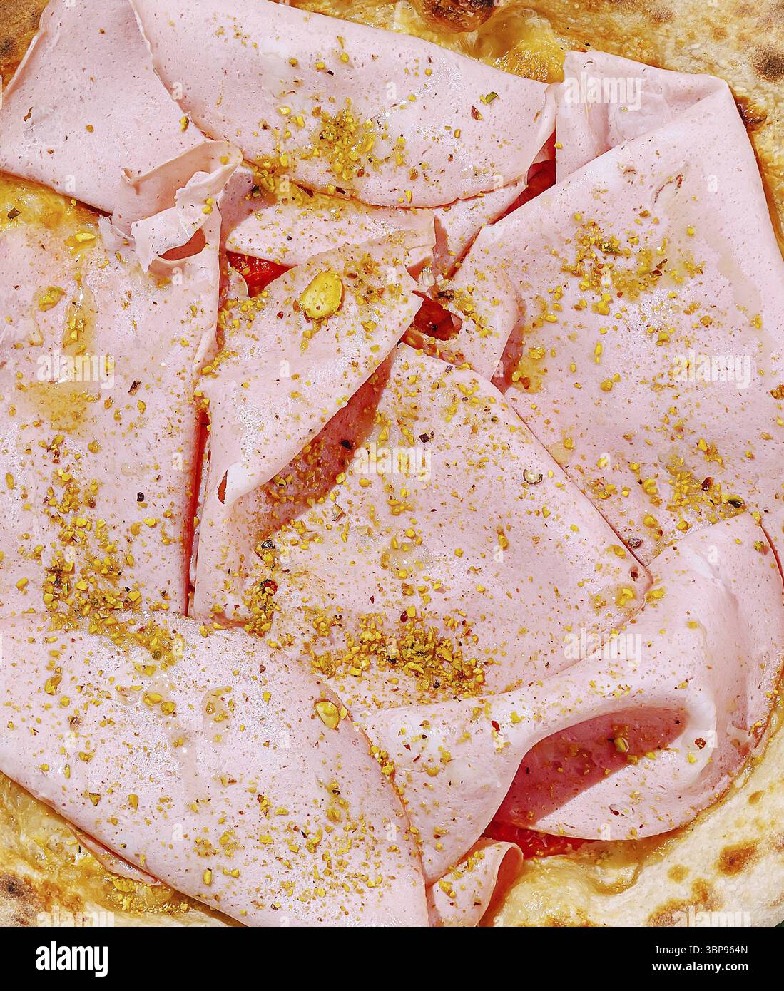 Cibo, Un piatto appetitoso con delicate fette di carne rosa condite con noci tritate e spezie, splendidamente disposte su una focaccia croccante. Perfe Foto Stock