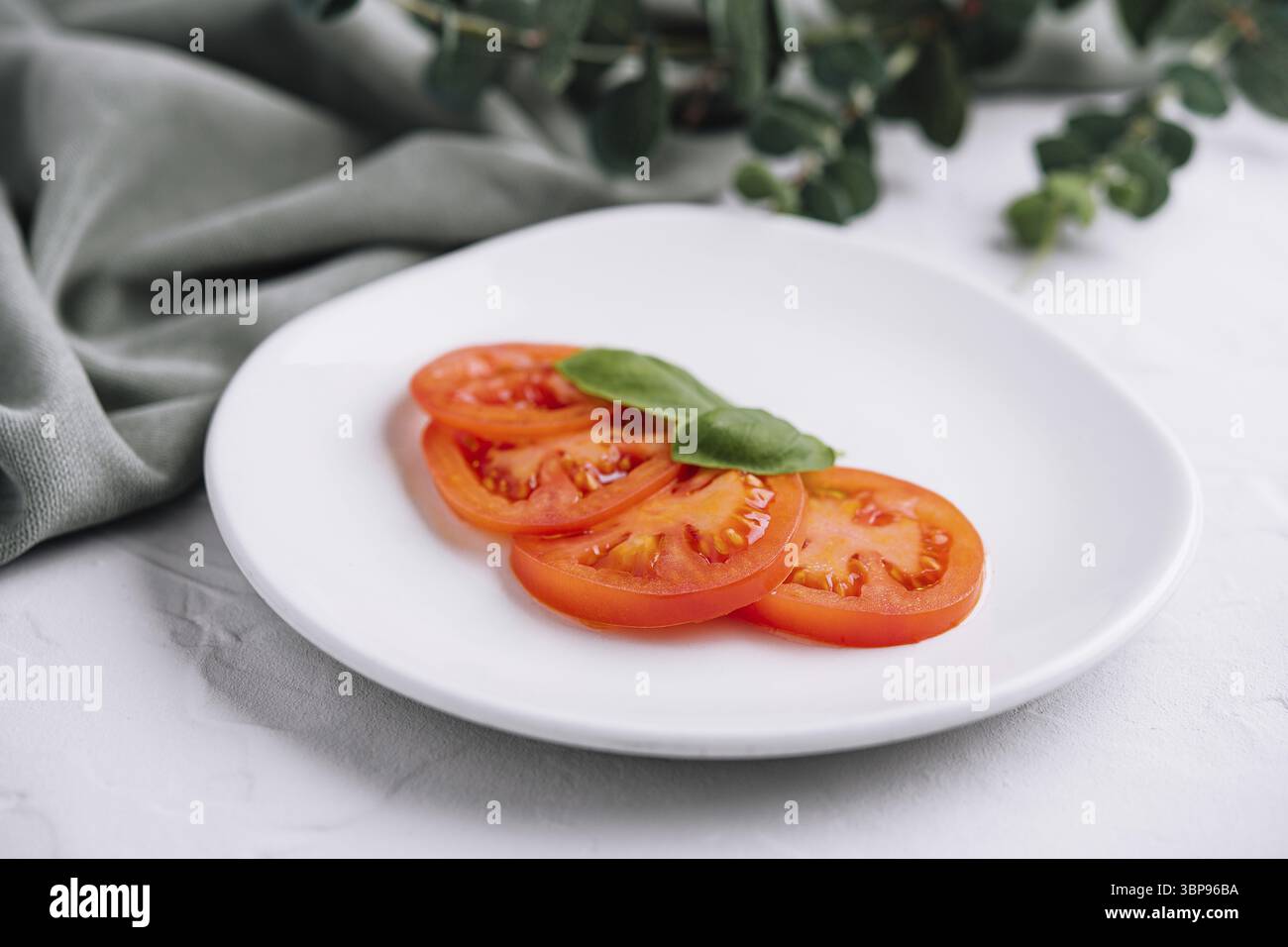 Cibo, Geschnittene rote Tomaten e Basilikumblaetter Foto Stock