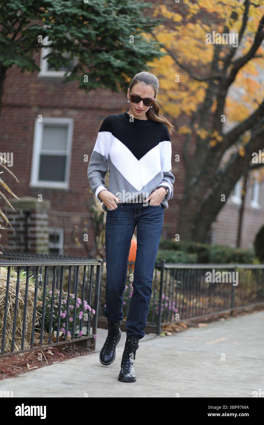 Una donna in abiti casual che esce dall'edificio ad Halloween Foto Stock