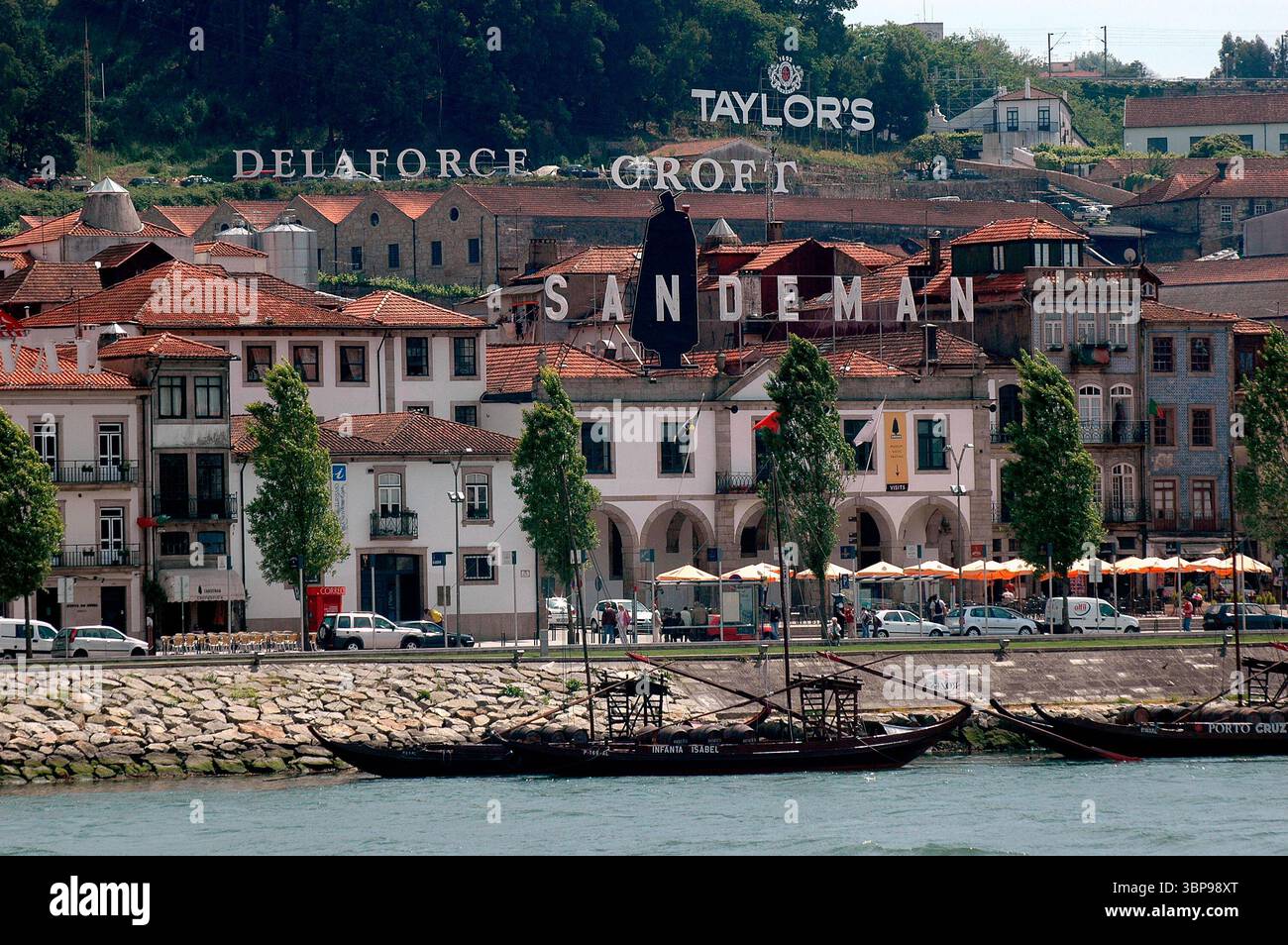 Una vista di Vila Nova de Gaia, Portogallo, con il fiume Douro in primo piano. L'immagine presenta i loghi di aziende vinicole portuali come Taylor's, D. Foto Stock