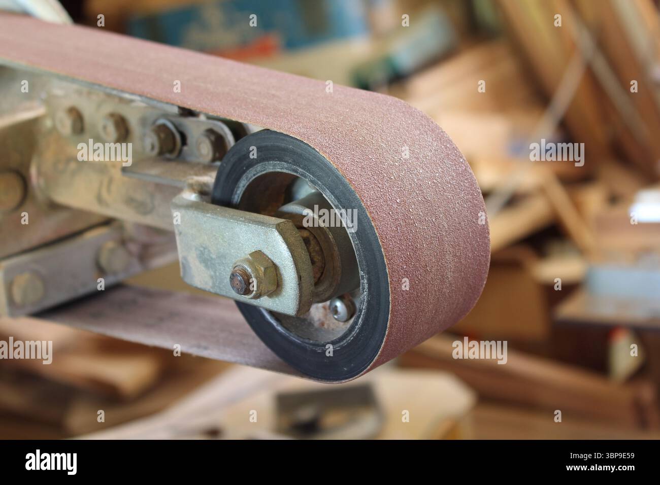 Primo piano di un'attrezzatura smerigliatrice a nastro in un capannone di officina Foto Stock