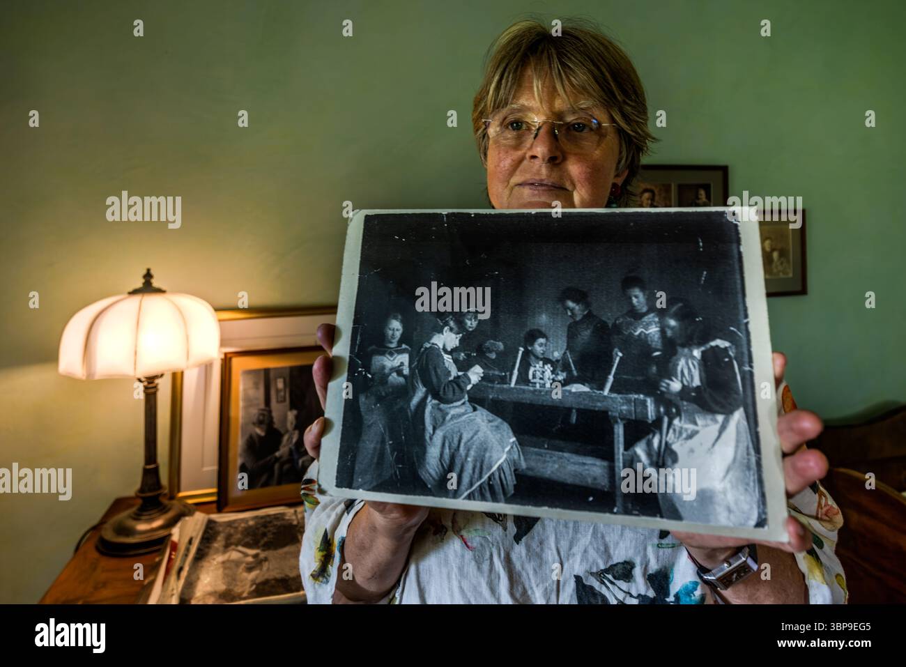 Eva Eberwein, co-proprietaria e curatrice della casa mia e Hermann Hesse a Gaienhofen, mostra una fotografia di mia Hesse che mostra una scena non posata di alunni in una scuola femminile. Quasi tutte le persone raffigurate sono impegnate in un'attività. Hermann-Hesse-Weg, Gaienhofen, Baden-Württemberg, Germania Foto Stock