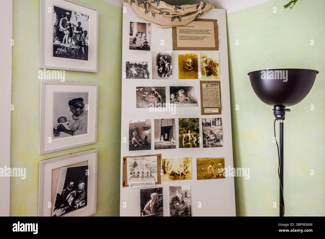 Una tavola espositiva con numerose fotografie dei tre figli di Mia Hesse è esposta nella Casa Mia e Hermann Hesse a Gaienhofen, Baden-Württemberg, Germania, accanto a fotografie familiari incorniciate, tra cui una di una madre che tiene un bambino. Mia Hesse fu la prima fotografa professionista della Svizzera e gestì uno studio fotografico a Basilea dal 1903. Le fotografie in mostra documentano la vita di campagna della famiglia con Hermann Hesse sulla penisola di Höri. Foto Stock