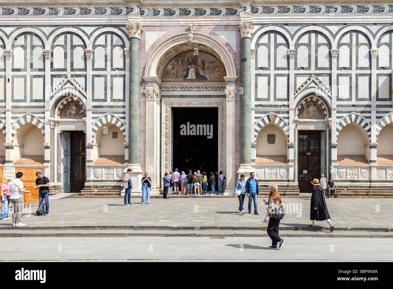 Firenze, Italia - 11 maggio 2025: I turisti entrano nella Basilica di Santa Maria Novella, ammirando la sua dettagliata facciata rinascimentale Foto Stock