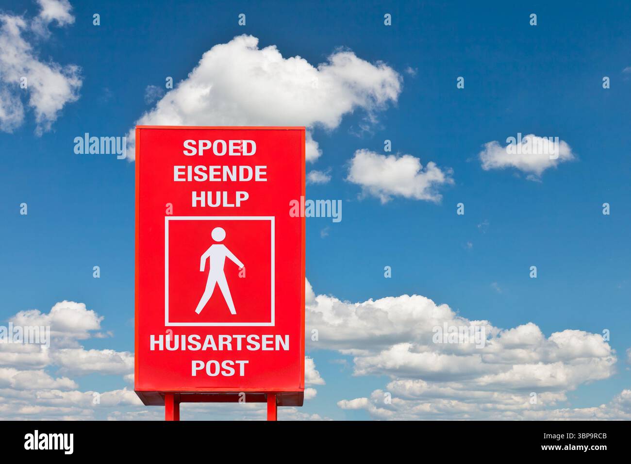 Cartello stradale con il testo olandese per "cure Emercengy" e "medico di famiglia/centro medico di famiglia" di fronte a un cielo blu Foto Stock